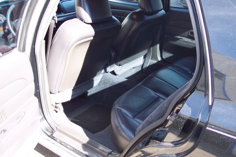 2001 Ford Crown Victoria - The interior of a black sedan is visible, with a focus on the seats and door panel.