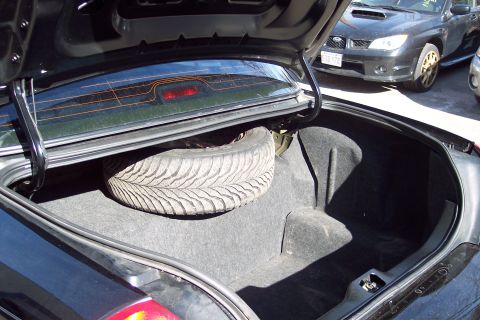 2001 Ford Crown Victoria - View of a car's trunk interior with a spare tire, and another vehicle in the background.