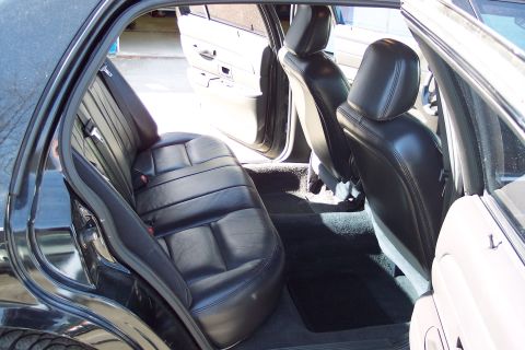 2001 Ford Crown Victoria - Interior view of a 2001 Ford Crown Victoria, showing the black leather seats and door panels.