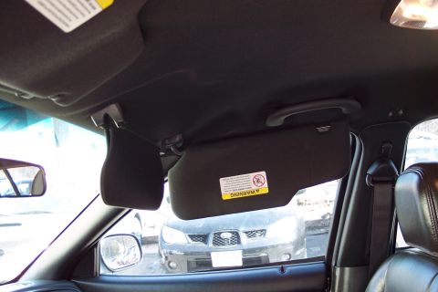 2001 Ford Crown Victoria - The interior of a vehicle is shown, with a warning label on the passenger sun visor.