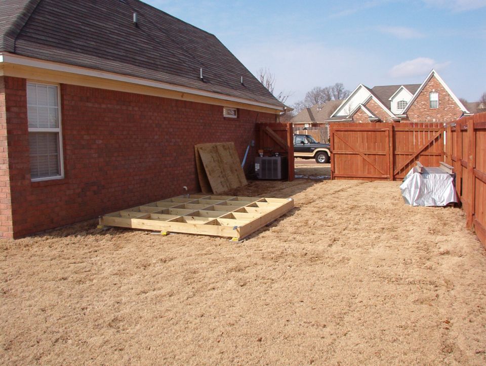 I had to wait for ~4" of snow & ice to melt before I could build the floor frame.  It's resting on concrete pads, each in a laser-levelled pocket of scarified dirt.  The shed is in the box under the tarp against the fence.
