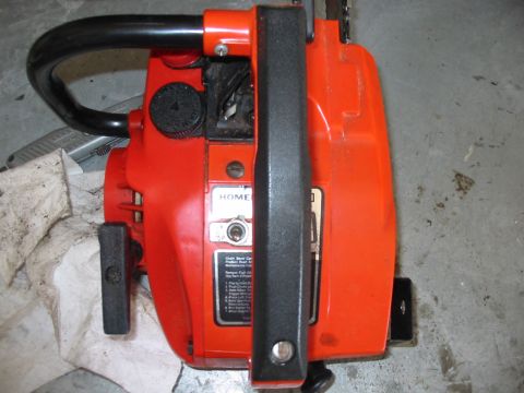 1992 Ford Bronco - A close-up view of an orange chainsaw, showing its handle and operational instructions.