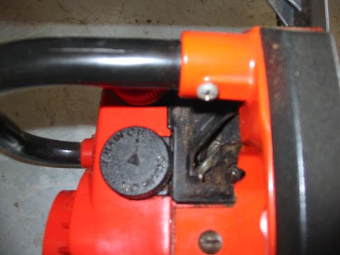 1992 Ford Bronco - The image shows a close-up view of a chainsaw, focusing on its chain oil reservoir cap and part of the handle.