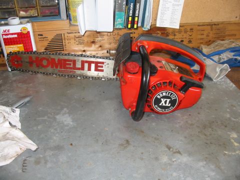 1992 Ford Bronco - A red Homelite XL chainsaw rests on a workbench next to a bottle of acetone.