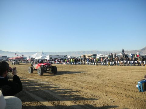 1997 Ford Ranger - An off-road buggy competes on a sandy track during an event, with spectators and RVs lining the course.