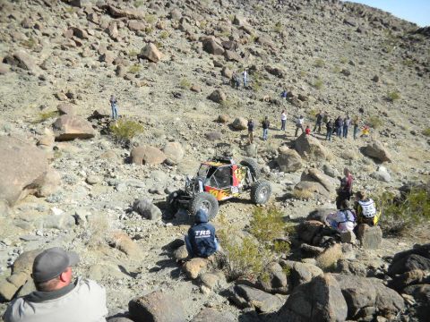 1997 Ford Ranger - A custom-built off-road buggy navigates a steep, rocky terrain with onlookers observing the race.