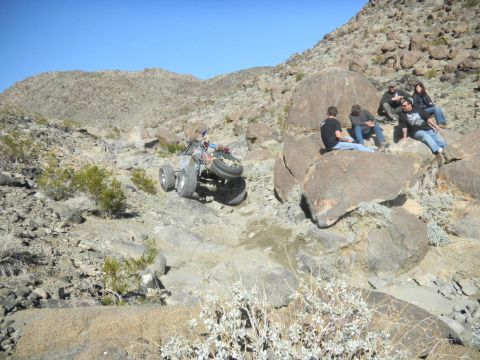 1997 Ford Ranger - An off-road buggy tackles a challenging rocky incline with spectators watching from the side.