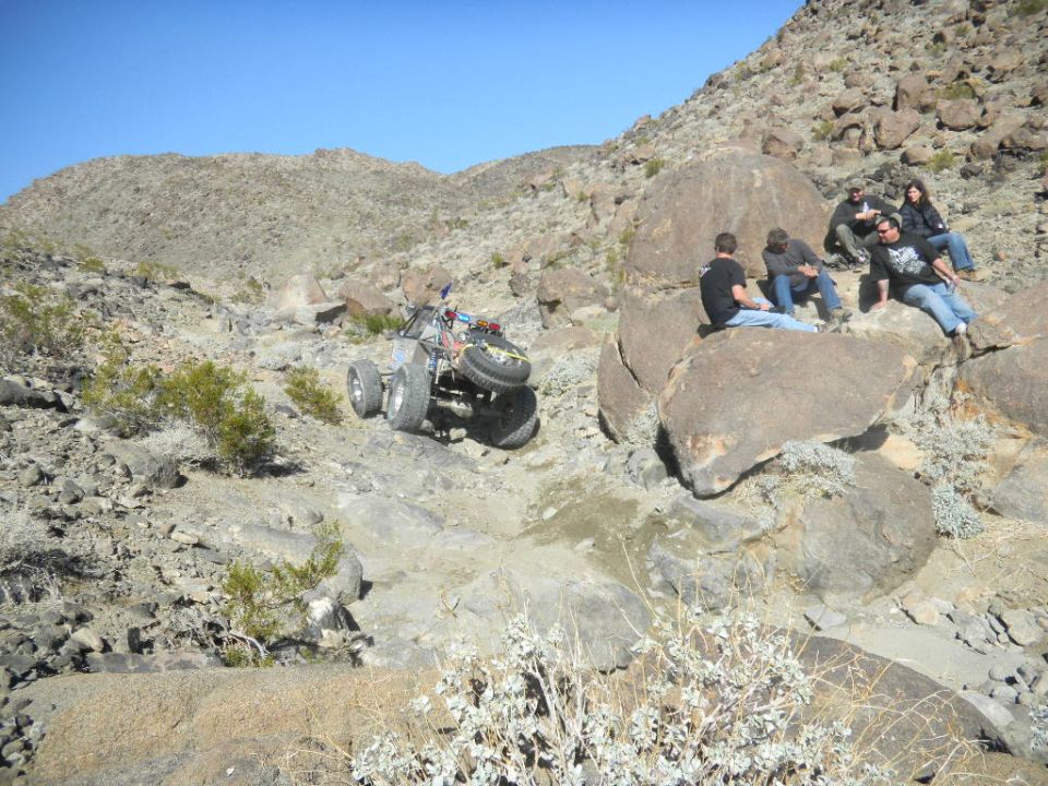 Off-road buggy with spare tire on back navigates rocky terrain