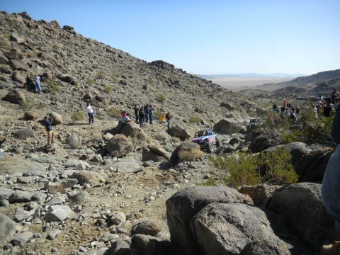 1997 Ford Ranger - Spectators watch as off-road vehicles traverse a challenging, rocky desert landscape.