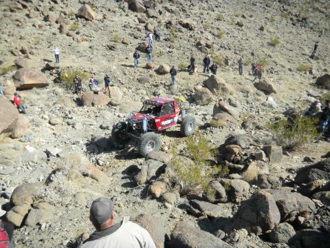 1997 Ford Ranger - A custom-built off-road buggy navigates a steep, rocky terrain with onlookers observing the race.