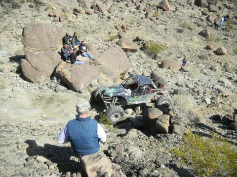 1997 Ford Ranger - A custom-built off-road buggy tackles a challenging rocky incline in a desert landscape.