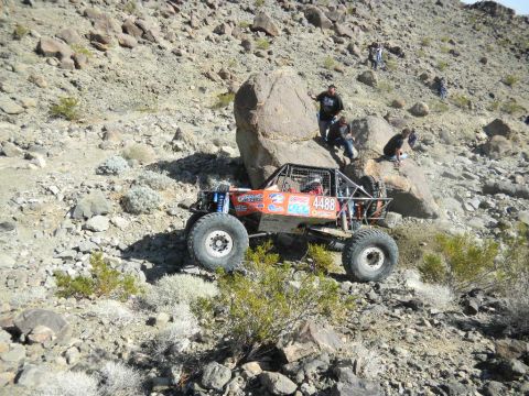 1997 Ford Ranger - A custom-built off-road buggy navigates a steep, rocky incline during a race event.
