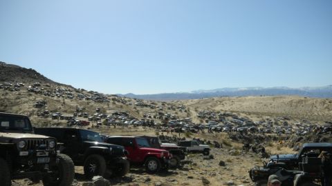 1997 Ford Ranger - A large gathering of off-road vehicles are parked on a desert hillside.