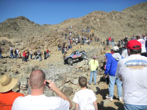 1997 Ford Ranger - A modified truck navigates a steep, rocky course with many onlookers.