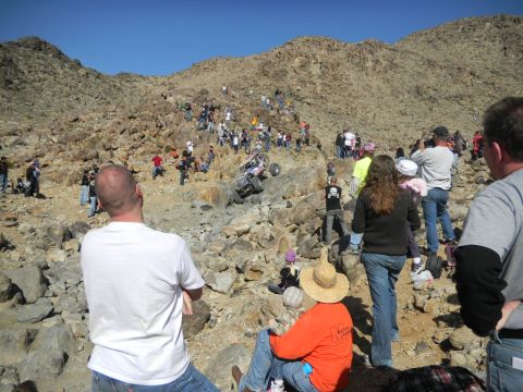 1997 Ford Ranger - Spectators watch an off-road buggy navigate a steep, rocky incline during a race event.