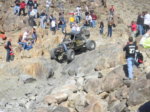 1997 Ford Ranger - An off-road buggy navigates a steep, rocky incline with onlookers observing the challenging course.