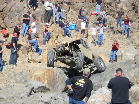 1997 Ford Ranger - A custom off-road buggy navigates a steep, rocky terrain with spectators observing the challenging climb.
