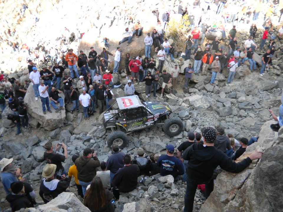 Off-road buggy with Monster Energy sponsorship navigating a rocky terrain