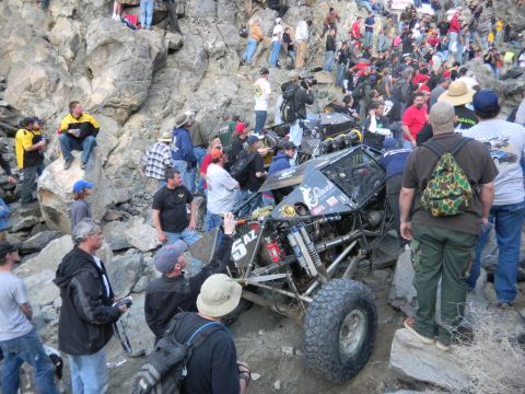 1997 Ford Ranger - A crowd gathers around a heavily modified off-road buggy navigating a rocky terrain.