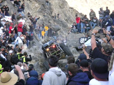 1997 Ford Ranger - A custom off-road buggy navigates a challenging rocky terrain, drawing a crowd of onlookers.