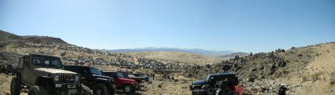 1997 Ford Ranger - A panoramic view captures multiple Jeeps parked in a desert terrain, with distant mountains under a bright blue sky.