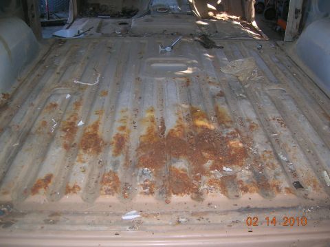 1985 Ford Bronco - Interior floor of a vehicle showing significant rust and debris, dated 02.14.2010.