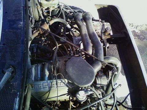 1990 Ford Bronco - The engine bay is shown with various hoses and wiring. Text on the engine block reads 'COBRA'.
