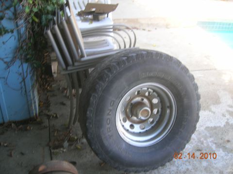 1985 Ford Bronco - Tire and rim assembly, possibly for an off-road vehicle, photographed outdoors.