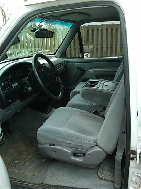 1997 Ford F-250 - Interior view of a 1997 Ford F-250 pickup truck, showing the driver and passenger seats, dashboard, and door paneling console.