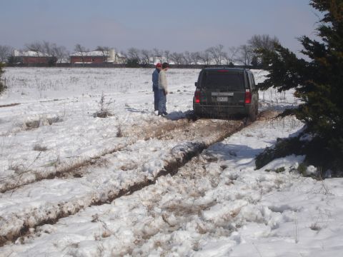 2002 Ford Expedition - A dark 2002 Ford Expedition is stuck in a muddy, snow-covered field.