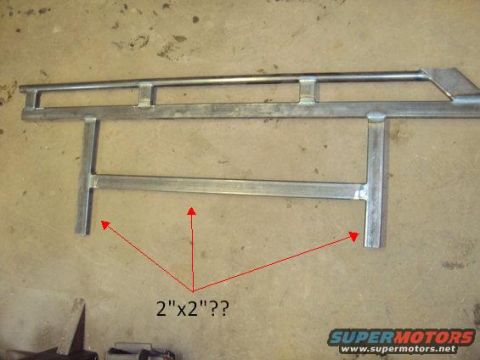 1996 Ford Bronco - Two bare-steel fabricated rock slider / nerf bar assemblies laid out on a concrete garage floor, built from square and rectangular tubing w…