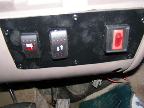 1993 Ford Bronco - Aftermarket switches are installed on the dashboard, including one red rocker switch and two with directional arrows.
