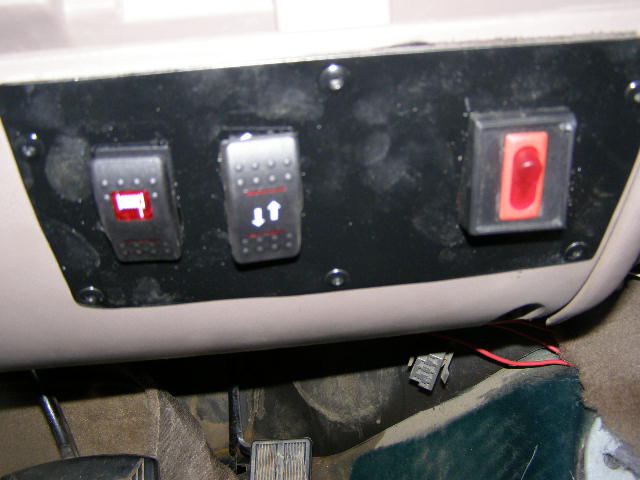 Interior dashboard with three aftermarket switches, one red, two with up/down arrows