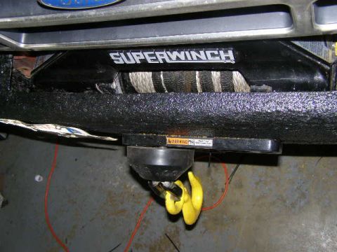 1993 Ford Bronco - Close-up of an aftermarket Superwinch mounted on a vehicle's front bumper.