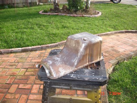 1978 Ford Mustang II - A rusty oil pan rests on a sawhorse in a backyard setting.