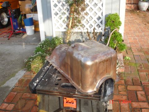 1978 Ford Mustang II - A weathered oil pan rests on a portable sawhorse outdoors.