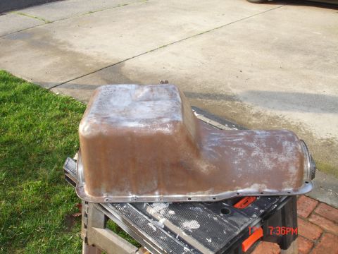 1978 Ford Mustang II - A used oil pan is shown resting on a portable sawhorse.
