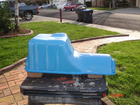 1978 Ford Mustang II - A blue painted oil pan is displayed outdoors on a workbench.