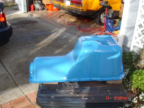 1978 Ford Mustang II - A blue oil pan is shown in a garage setting, with a yellow car in the background.