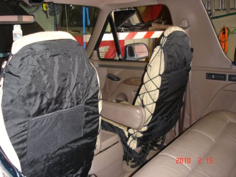 1995 Ford Bronco - Interior view of the front seats, showing seat covers and the driver's side window.