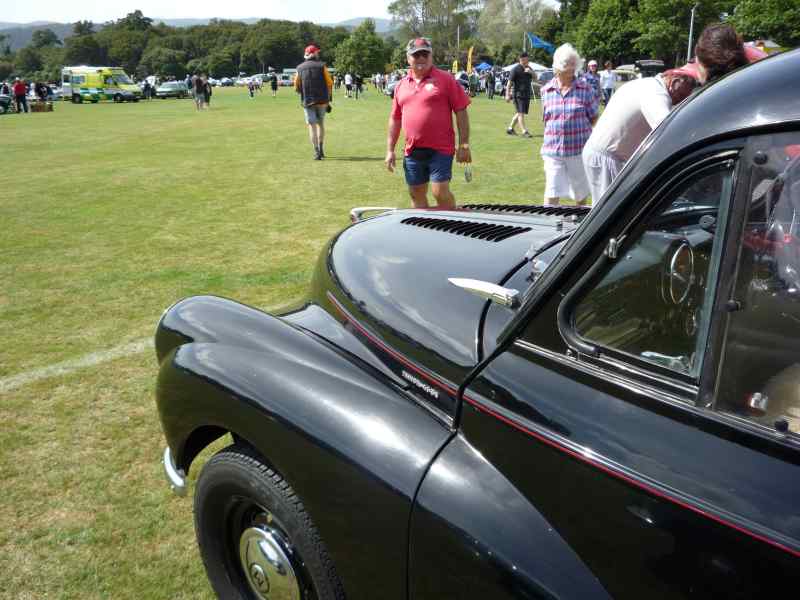 Black classic car, 3/4 front view. Appears to be from the 1950s