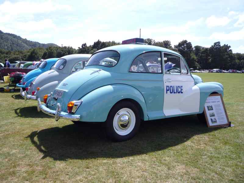 Light blue and white police car, rear quarter view, with "POLICE" text on door