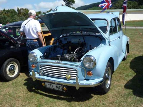 1969 MINI Cooper - A light blue classic car, possibly a Morris Minor, is displayed with its hood open, revealing the engine compartment. The license plate rea…