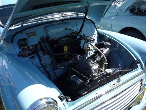 1969 MINI Cooper - Close-up of a classic car's engine bay, with another vehicle in the background.