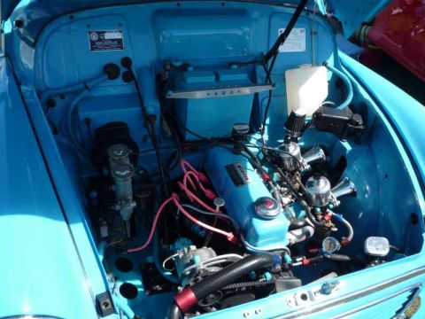 1969 MINI Cooper - The engine bay of a 1969 MINI Cooper displays its twin SU carburetors and a blue 'MORRIS' valve cover.