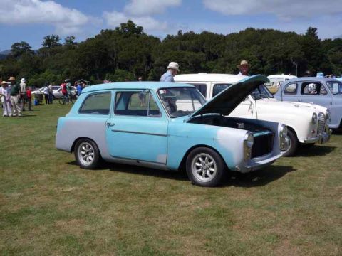 1969 MINI Cooper - A light blue and grey Austin A40 Farina Countryman is displayed outdoors with its hood up, alongside other vehicles.