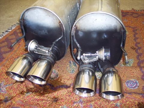 2006 Chevrolet Corvette - Close-up of two exhaust mufflers, each with dual chrome tips and visible active exhaust valve mechanisms.