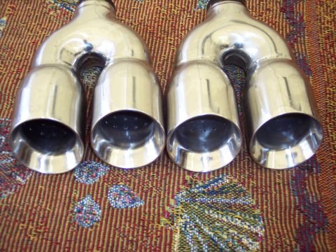 2006 Chevrolet Corvette - Pair of chrome exhaust tips, likely for a performance vehicle, shown on a patterned surface.