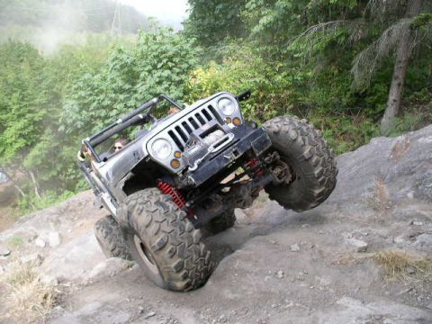 1979 Ford Bronco - A modified Jeep Wrangler navigates a steep, rocky off-road trail.