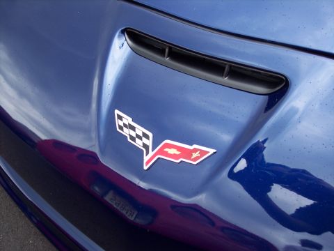 2006 Chevrolet Corvette - The emblem on the hood of a blue Corvette shows the iconic crossed flags with a Chevrolet bowtie.